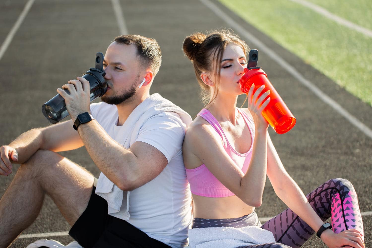 Dos deportistas hidratándose